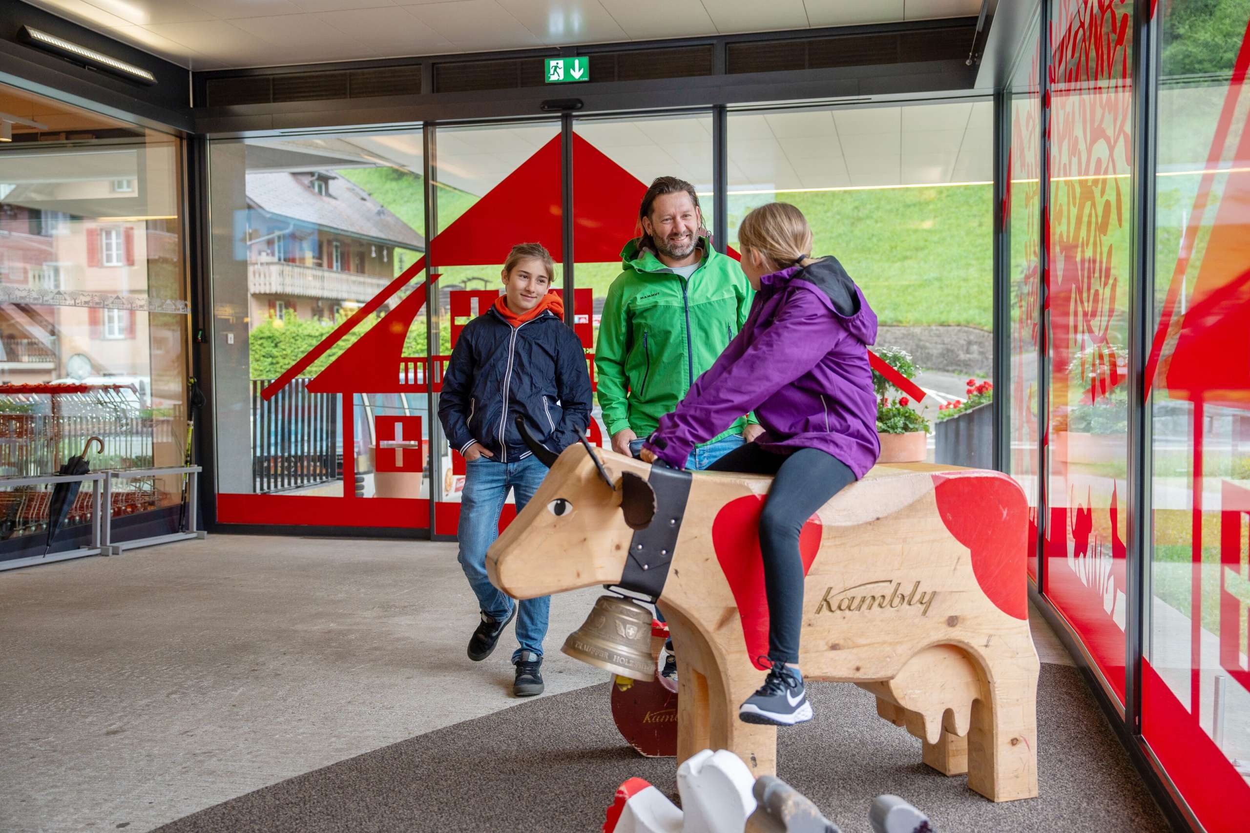 Eine Familie entdeckt die Angebote der Kambly Erlebniswelt. Die Kinder setzen sich auf die grossen Holztiere und erfahren viele Informationen über die Herkunft der Rohstoffe für die Kambly Biskuits.