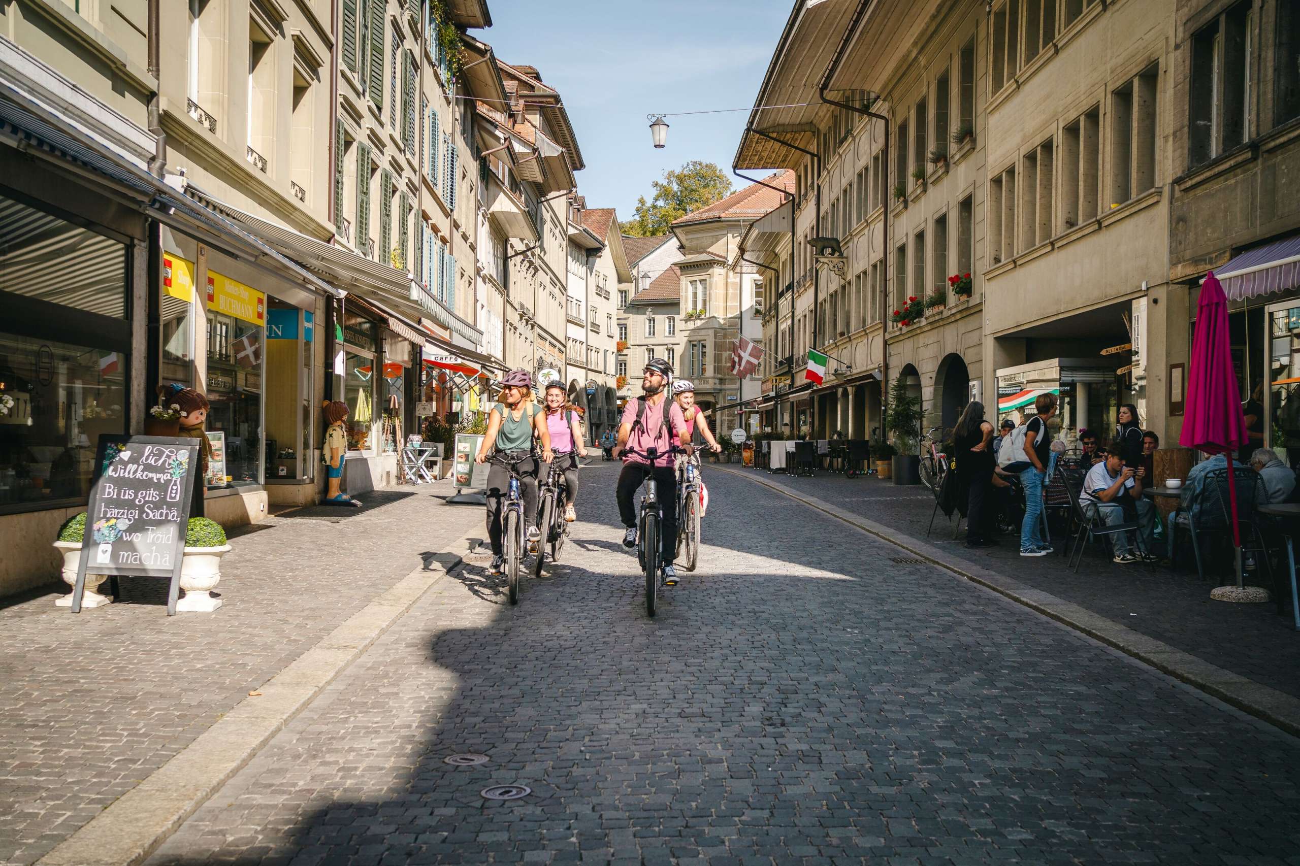 Eine Gruppe von vier Personen fährt mit den E-Bikes durch die Schmidengasse in der oberen Altstadt Burgdorf.